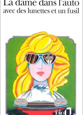 La dame dans l'auto avec des lunettes et un fusil